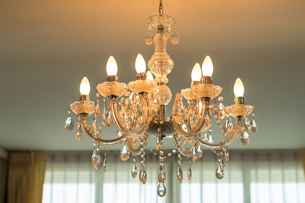 A light fixture/chandelier turned on with yellow shining lights