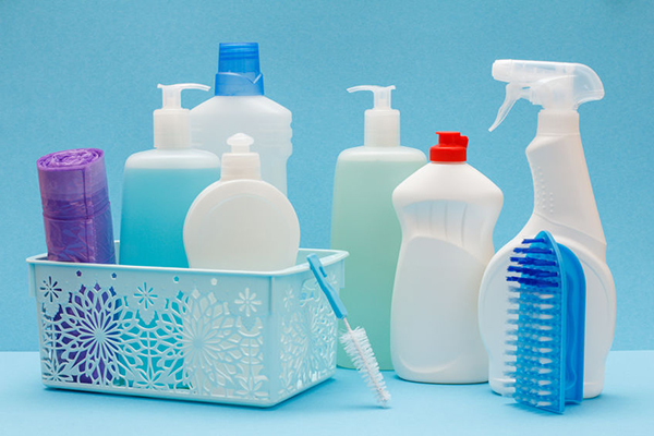 A group of cleaning supplies with a light blue background
